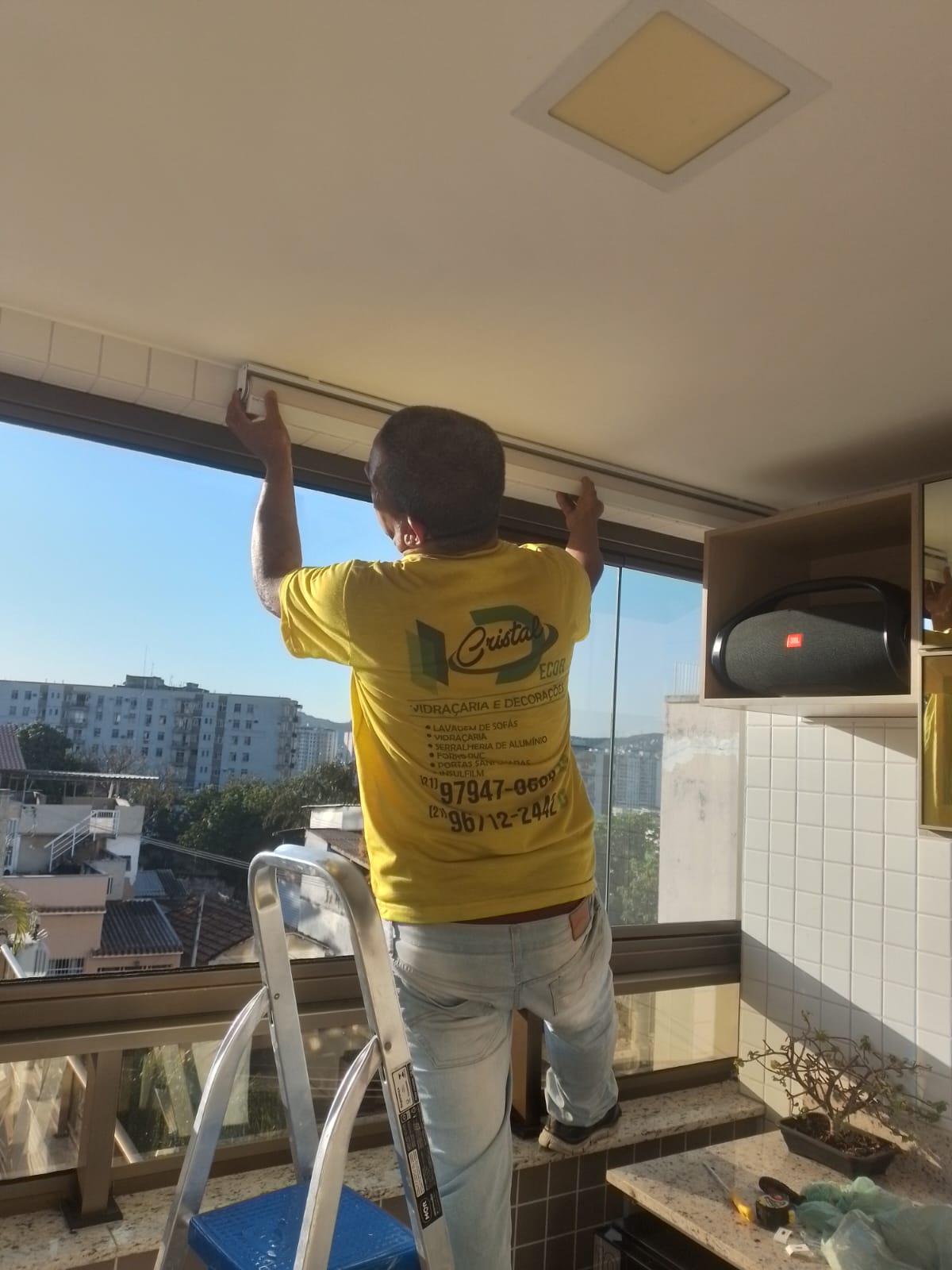 Técnico Cristal Decor instalando persiana - serviço profissional e uniformizado